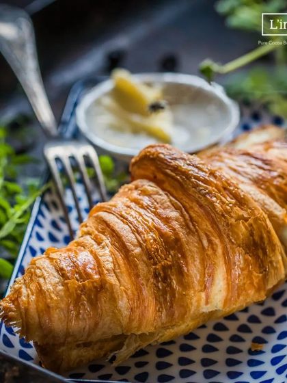 A classic butter croissant, served simply. Its beauty lies in the technique of lamination, creating those delicate layers. It’s the perfect companion to a cup of coffee or tea.
