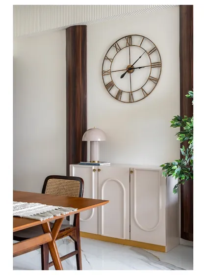 A quiet corner in 'Apartment 601'. The blend of a modern, handle-less crockery unit with a large, classic clock and cane chair embodies our signature Scandinavian-chic style.