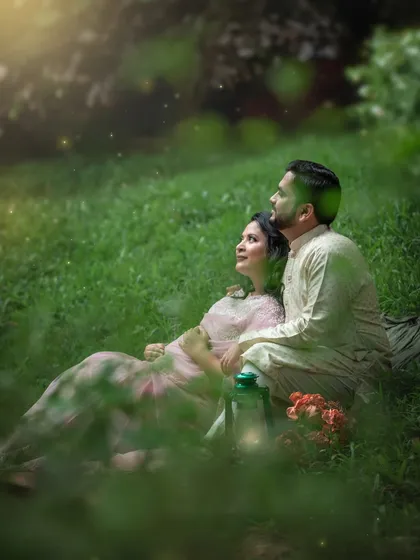 A quiet moment for an expecting couple, nestled in the grass with a lantern. The soft focus and glowing orbs of light add to the misty, magical feeling of the scene.