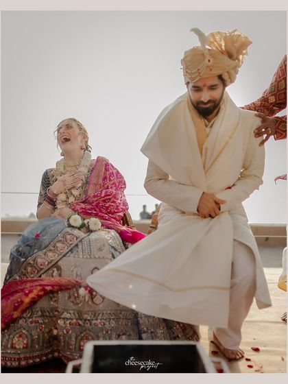 A fun ritual during a Gujarati beach wedding where the groom playfully takes his time to sit, deciding who "rules" the marriage.