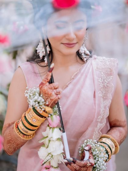 A serene Haldi portrait. The soft pink makeup tones complement the floral jewelry and the overall vibe of the ceremony.