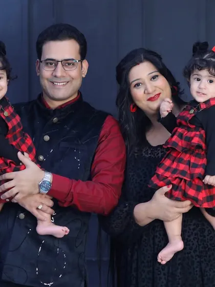 Double the fun! A beautiful family portrait with adorable twin girls in matching outfits. Capturing the personalities of two little ones at once is a delightful challenge.