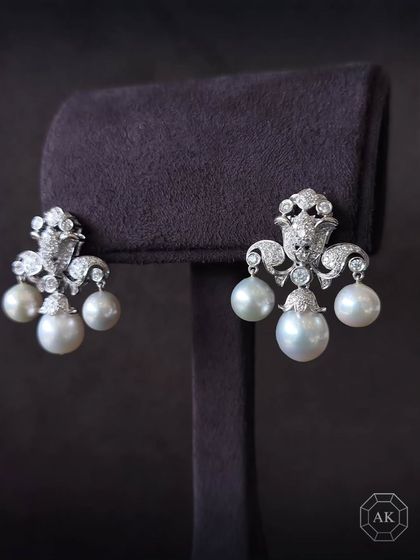 These South Sea pearl earrings are a masterpiece of elegance, crafted in radiant 18K gold and adorned with natural diamonds.