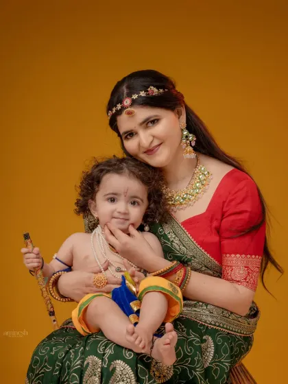 A classic mother and child portrait, with the mother gently holding her little Krishna's chin. This pose highlights the connection and affection between them.