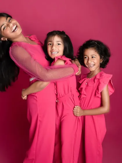 The bond between siblings is just the sweetest. These three sisters were an absolute delight, and their coordinated outfits against the vibrant pink backdrop made for such a fun and lively sibling photoshoot.