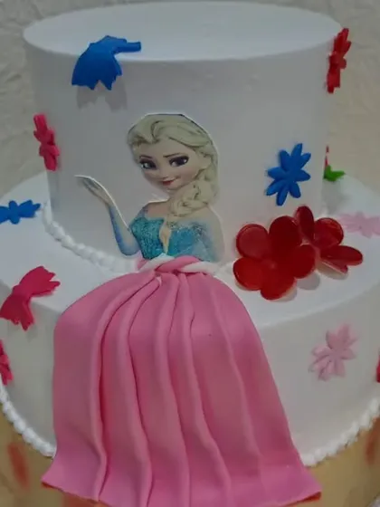 Another look at the two-tiered Elsa cake with the pink dress element, showing how I can combine different design ideas into one creation.
