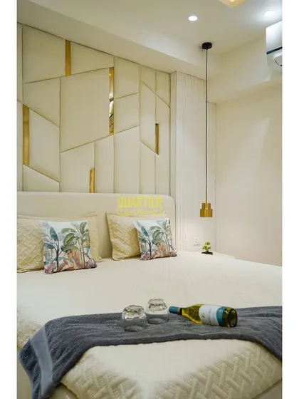 A full view of the bed in the Tata LaVida master bedroom, showcasing the complete effect of the custom headboard, pendant lights, and neutral color scheme. The room feels like a luxurious hotel suite.