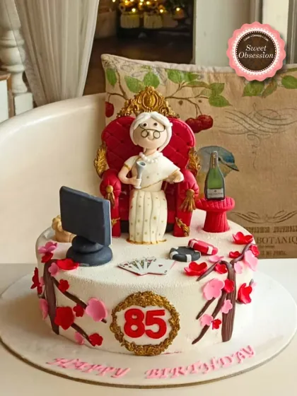 A fun and personal cake for an 85-year-old grandma who loves playing cards, featuring a fondant figure in a throne.