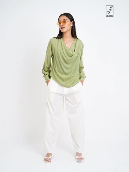 A full-length view of the green top and white pants, showing the relaxed yet elegant silhouette.