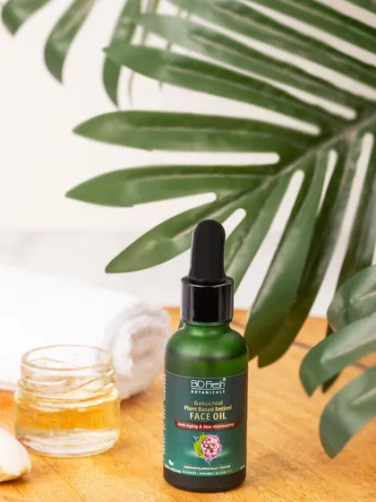 A spa-like setting for Biofresh Botanicals' face oil, styled with a towel, a small bowl of honey, and a palm leaf. This creates a serene and relaxing atmosphere.