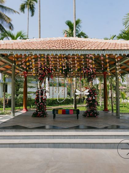 The engagement stage set in a beautiful outdoor location. The traditional architecture of the pavilion provides a perfect contrast to the modern, colorful decor.