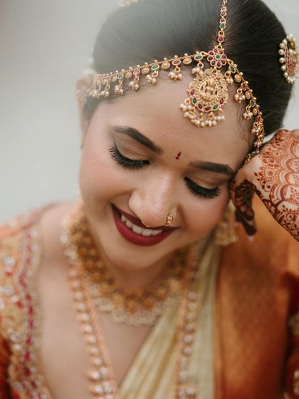 A quiet moment of reflection. The focus here is on the flawless eye makeup, with long lashes and perfectly defined brows, and the traditional matha patti that frames her face beautifully.
