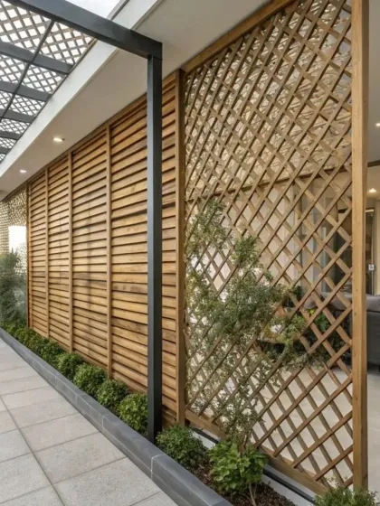 This outdoor space uses a combination of wooden louvered and lattice screens to create privacy and define the area. The different textures and patterns add visual interest while separating the patio from the surrounding environment.