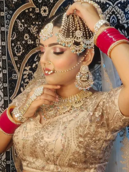 A model showcasing a beautiful silver-gold lehenga and a unique layered jewellery set.