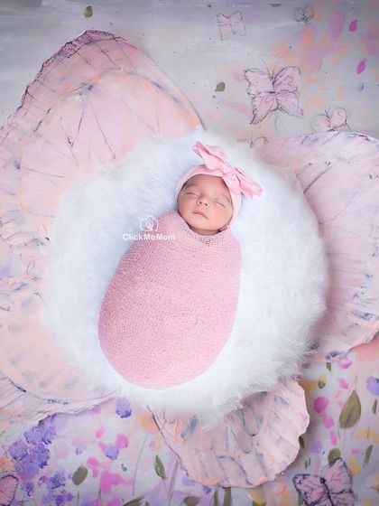 This baby has blossomed. Here she is, the center of a giant pink flower prop, creating a whimsical and artistic portrait.