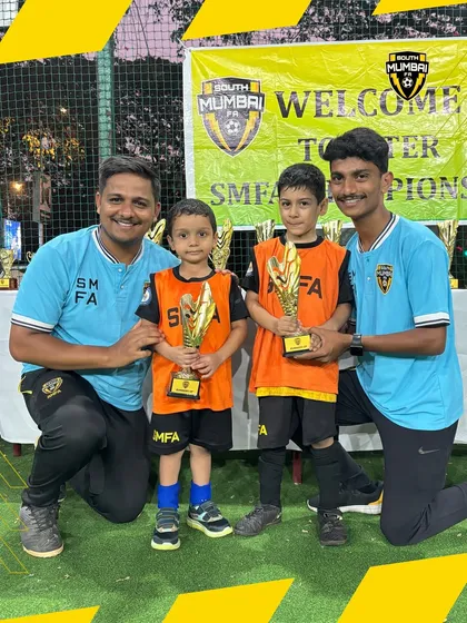 Two more little champions with their coaches. The smiles on their faces show the joy and pride they feel.