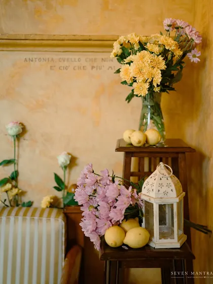 The quiet details of a haldi ceremony in Italy. I used simple, rustic elements like fresh lemons, yellow chrysanthemums, and a white lantern to style this corner, bringing a touch of Indian sunshine to the shores of Isola del Garda.