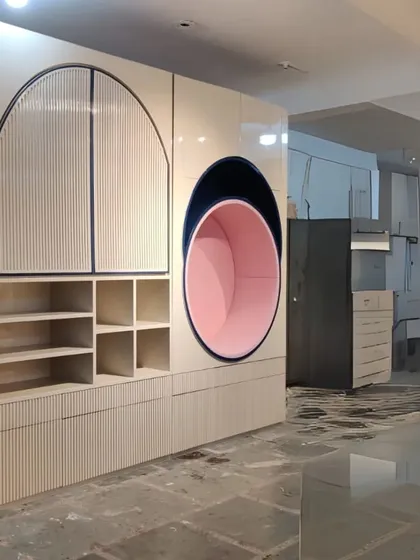 This unique storage unit, seen here in our workshop, features a playful design with an arched cabinet, open shelving, and a circular pink-lined nook. It's a perfect piece to add both storage and fun to a child's room or play area.