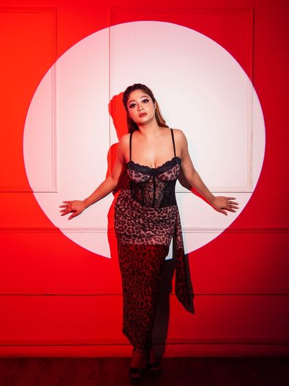 Another pose from the red spotlight series, this image has a strong graphic quality and showcases the model's expressive pose.