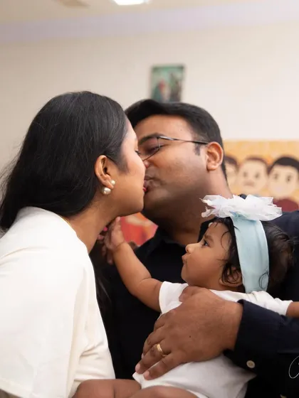 It looks like this little princess is not ready to share the spotlight. This funny and sweet moment of a family kiss, captured through a reflection, shows the playful reality of life with a toddler.