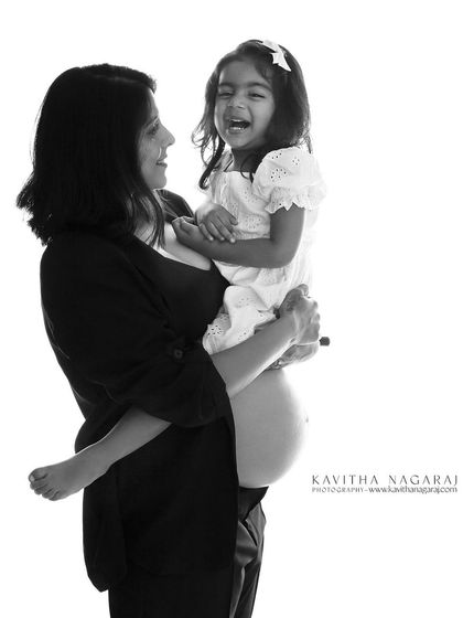 The joy of pregnancy is multiplied when shared with your loved ones. This black and white portrait of a mother and daughter laughing together is full of pure happiness.