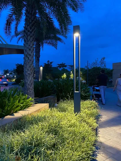 Landscape lighting is crucial for transforming a space after sunset. Here, I used sleek, modern bollard lights to illuminate pathways and highlight the textures of the ornamental grasses and palm trees, ensuring the landscape is safe, inviting, and dramatic at night.
