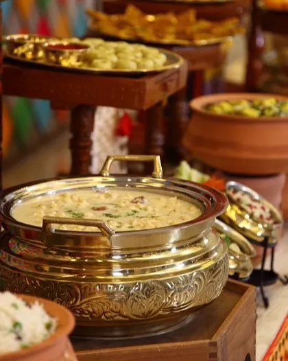 A beautifully arranged buffet of our Rajasthani specialties. The spread features a variety of dishes in traditional brass and clay pots, showcasing the grandeur of a royal Rajasthani feast.