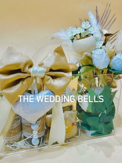 This chic acrylic bag hamper is a statement piece for Rakhi. Filled with dry fruits and decorated with a large bow, it's both elegant and useful.