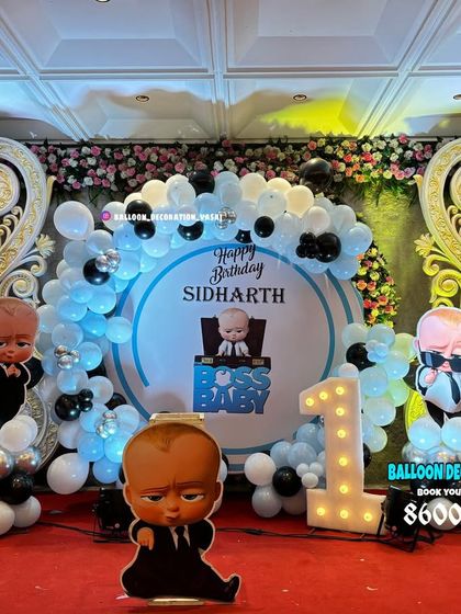 A grand Boss Baby theme for Sidharth's first birthday. This stage decoration includes a large round backdrop, ornate side panels, and multiple Boss Baby character cutouts.