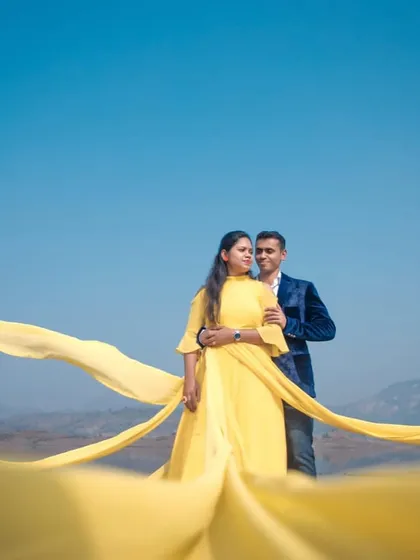 A full view of the yellow trail gown, showing how the long fabric can be styled to create a dramatic, windswept effect. This is a fantastic rental option for couples who want epic photos.