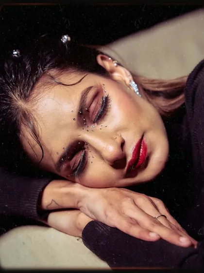 A close-up beauty shot from the 'Embrace Self' editorial. Notice the detailed makeup with facial gems and a bold red lip, which complements the overall theme of confident self-expression.