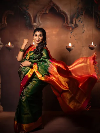 A joyful solo portrait of the mother-to-be. The flowing saree and her radiant smile capture the excitement and beauty of her pregnancy, set against a warm, traditional studio backdrop.