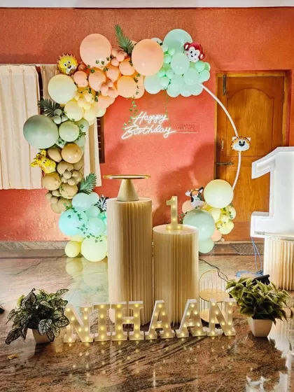 The complete home setup for Nihaan's first birthday, combining the balloon ring with cake stands and personalized decor.