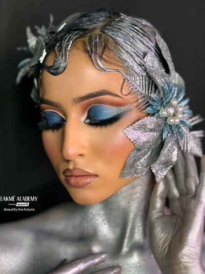 A full view of a fantasy look created by our students. The artistry extends from the face to the body, incorporating silver body paint and sculpted hair to create a cohesive, otherworldly character.