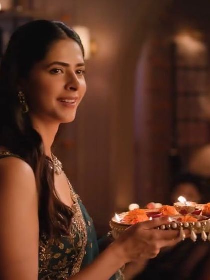 A beautiful still from the Xiaomi film, where the model's makeup looks soft and elegant in the warm, festive lighting.