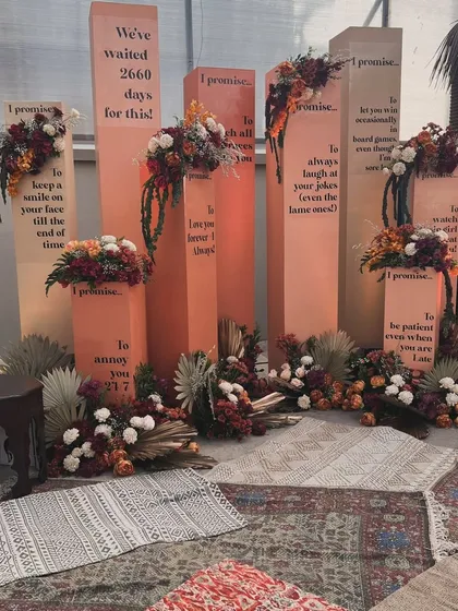 The promise pillars setup glowing in the evening light, surrounded by pampas grass and floral arrangements.