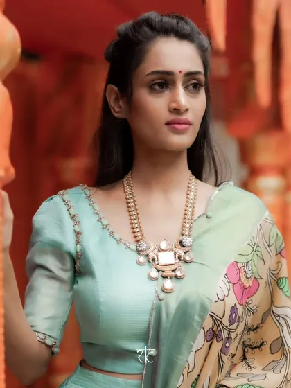 A portrait of the model wearing the sea blue lehenga and Kalamkari dupatta, a perfect blend of subtle elegance and bold traditional art.