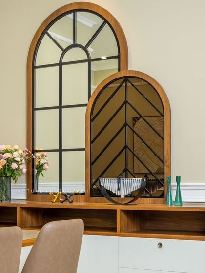 Decorative arched mirrors with wood and metal frames serve as a stunning focal point in this dining space, adding character and reflecting light to make the room feel larger.