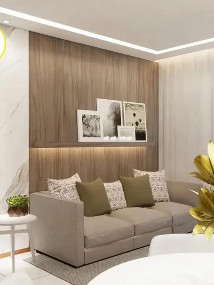 A serene living room corner with a light-colored sofa and a floating picture ledge. The combination of wood and marble textures creates a sophisticated and modern look.