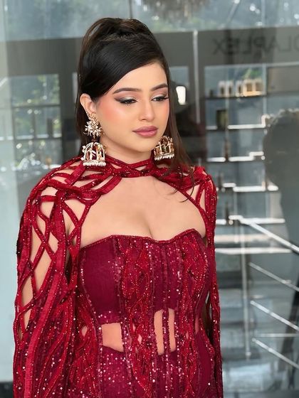 A full-length view of the modern engagement look. The bold red outfit is balanced with chic makeup and a sleek hairstyle, creating a powerful and stylish statement.