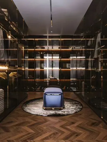 We create luxurious walk-in closets that are both a style statement and an organizational dream. This design uses smoked glass doors and integrated LED lighting to beautifully display clothing and accessories, turning a daily routine into a high-end experience.