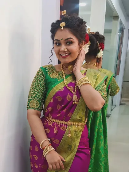 A festive look for Gudi Padwa, showcasing a traditional Maharashtrian hairstyle with an elaborate bun and classic makeup featuring a winged liner and pink lips.