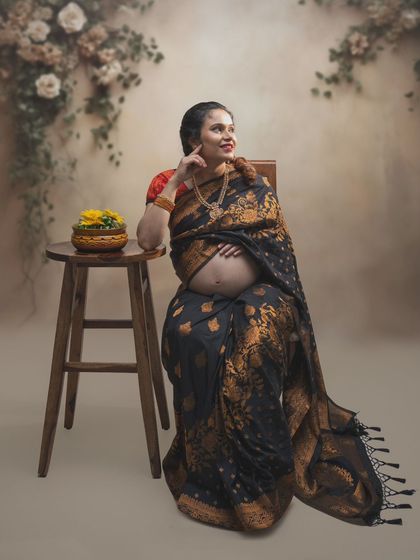 Blooming in grace and anticipation. This portrait captures a mood of tradition, beauty, and quiet contemplation in a stunning black and gold saree.