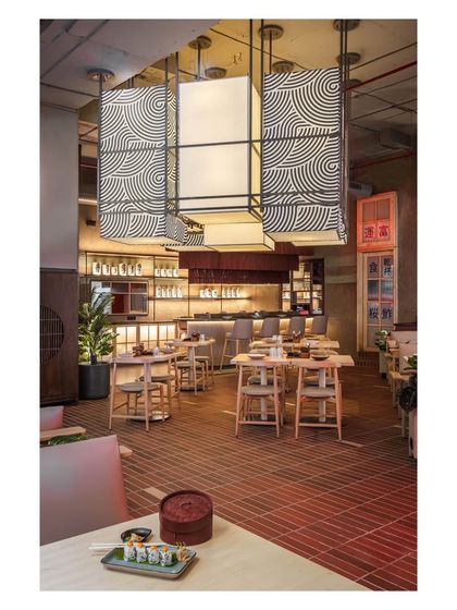 The custom designed lantern-style lights are a central feature, with bold geometric patterns that add a modern twist to a traditional form. They illuminate the space while also serving as large scale art installations.