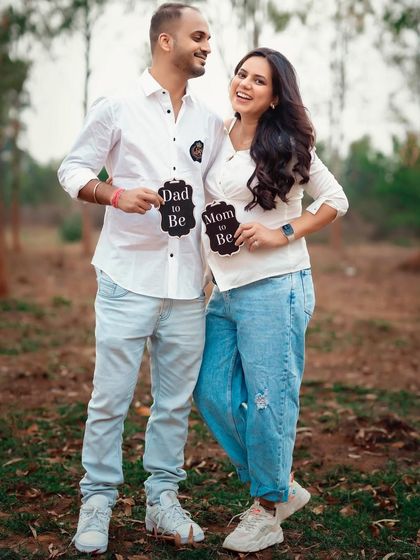 A fun and casual outdoor shot with "Mom to Be" and "Dad to Be" signs. This is a great way to show your playful side as a couple.