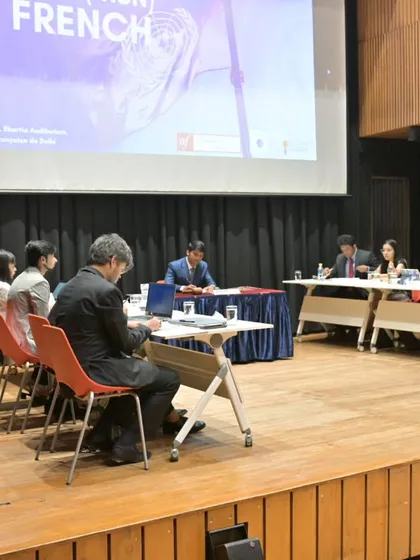 The MUN in session, with students deeply engaged in debate and discussion on topics like cybersecurity and the digital divide, all conducted "en français".