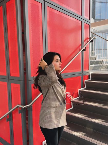 A candid, hair-fixing moment from the same college outfit series, adding a natural and relatable feel.