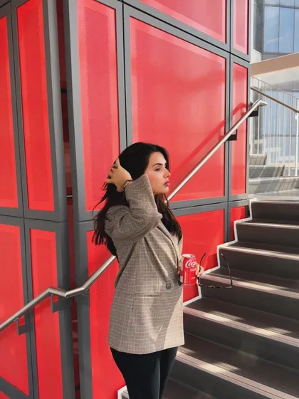 A candid, hair-fixing moment from the same college outfit series, adding a natural and relatable feel.