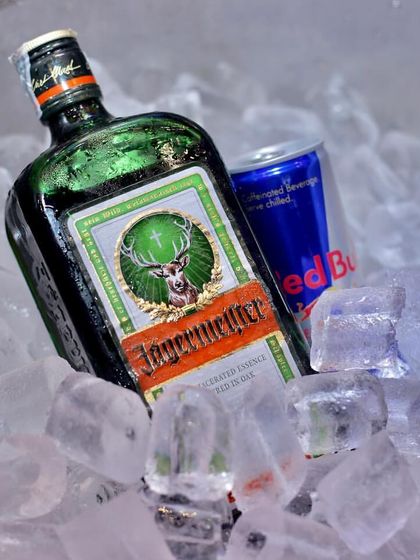 A bottle of Jägermeister and a can of Red Bull chilling on ice. This simple but effective setup is for the classic Jager Bomb station, always a favorite at high-energy parties.