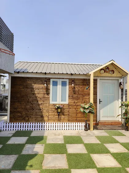 We offer a variety of styles to match your vision. This charming prefabricated cottage brings a rustic, cozy feel to a city rooftop, creating a perfect personal getaway with its wood-paneled exterior and welcoming entrance.